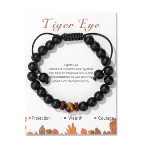 Dettaglio del bracciale con occhio di tigre, pietre nere opache e cordino intrecciato