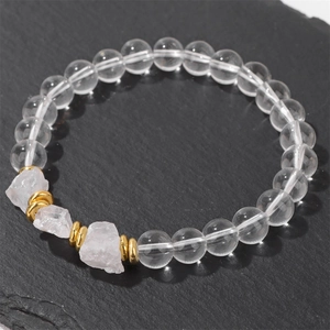 Dettaglio macro di perline trasparenti e pietre naturali rosa su bracciale minimalista