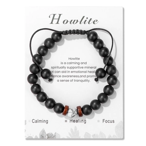 Dettaglio di howlite e perle nere opache su bracciale intrecciato regolabile con carta