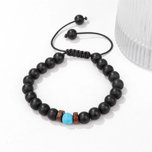 Dettaglio del bracciale intrecciato regolabile con perline nere opache e accento