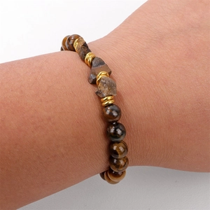 Dettaglio di perle occhio di tigre e pietre minerali grezze su un bracciale di perline