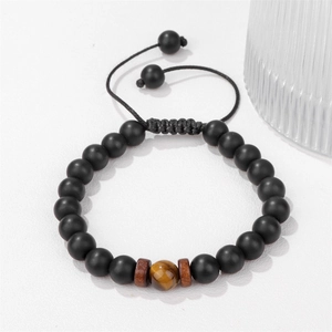 Dettaglio macro del bracciale regolabile occhio di tigre con perline nere opache e corda