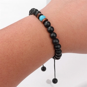 Dettaglio del bracciale regolabile occhio di tigre con perle di onice opaco al polso