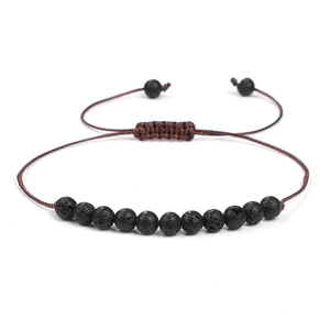 Détail des perles de lave 8mm et du cordon tressé marron réglable sur un bracelet perlé