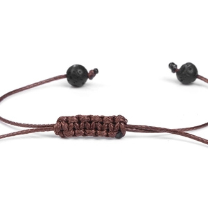 Gros plan d'un bracelet tressé marron avec perles en pierre de lave et nœuds carrés