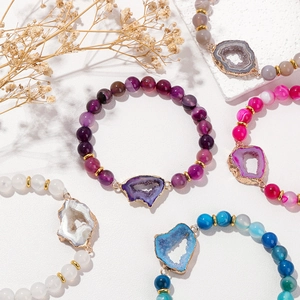 Detalle de pulsera de ágata natural con bordes dorados y cuentas de piedra pulida