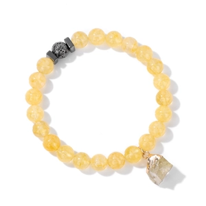 Nahaufnahme vom gelben Kristallarmband mit Naturstein-Anhänger und schwarzem Lavastein