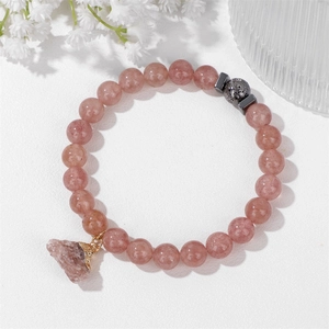 Makroaufnahme von Erdbeerquarz-Perlen und Naturstein-Anhänger am elastischen Armband