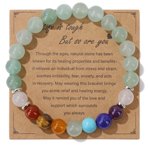 Detail of natural stone elastic bracelet with colorful beads on kraft paper card packaging