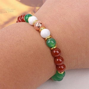 Close-up of a beaded Christmas bracelet featuring natural stones and a rose gold hollow charm