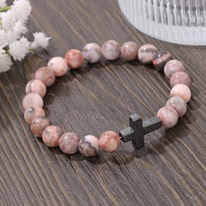 Bracelet en perles de pierre impériale avec breloque croix de 8mm sur fond de bois naturel