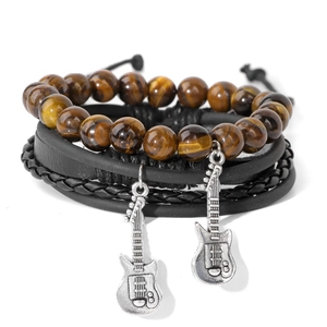 Close-up of four-piece multilayer bracelet set with tiger eye beads and guitar charms