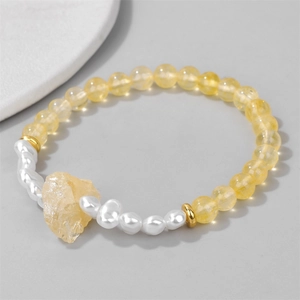 Macro shot of 6mm yellow quartz beads and baroque pearls with gold metal spacers