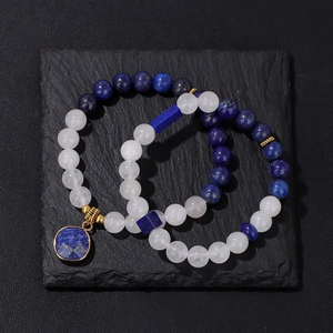 Detail eines Perlenarmbands mit Lapislazuli, Weißkristall und Gold-Distanzstücken auf Stein