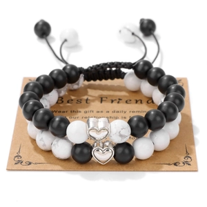 Macro detail of friendship beaded bracelets with heart pendants on a Best Friend card