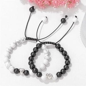 Detail of adjustable couple bracelets with white turquoise beads and heart charms