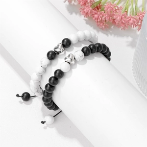 Detail showing adjustable couple beaded bracelets with silver heart charms and stones