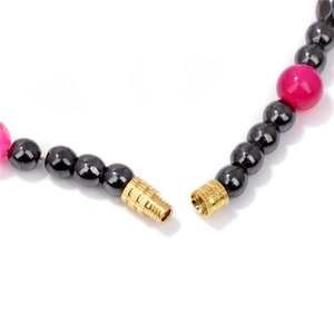 Retro agate necklace with hematite beads and gold spiral clasp on white background