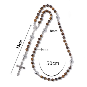 Details van 8mm tijgeroog kralen en zilveren crucifix hanger aan religieuze ketting