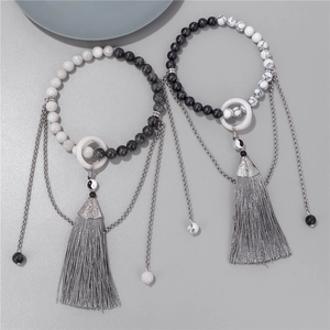 Détail de bracelets en perles de style chinois avec charmes Yin Yang et glands en soie
