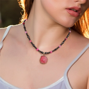 Detail of beaded necklace with agate slice pendant and gold edging on model