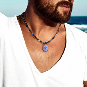 Men's beaded necklace with blue agate pendant and black hematite beads at the beach