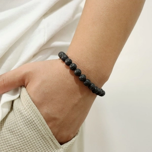 Nahaufnahme eines 8mm Lavastein-Armbands mit natürlicher Textur am Handgelenk