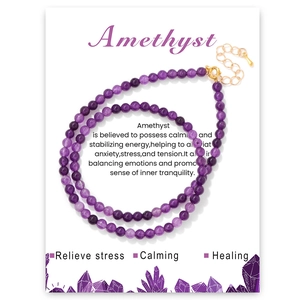 Macro detail of natural 4mm amethyst beaded jewelry with gold clasp on info card