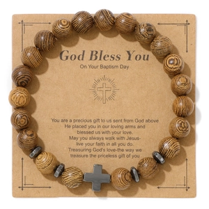 Detail of wooden beads bracelet with grey cross pendant on a religious baptism gift card