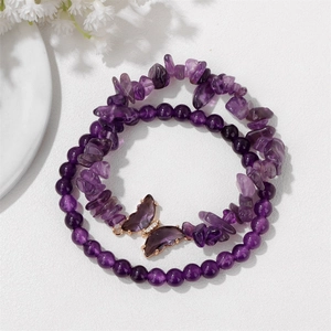 Detail von Amethyst-Perlenarmband mit lila Schmetterlingsanhänger und Goldakzenten