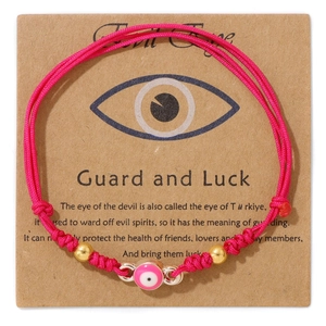 Rosa Evil Eye Armband mit Goldperlen auf einer braunen Markendisplaykarte