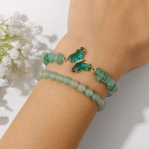 Detailansicht des doppelten grünen Naturstein-Armbands mit goldenem Schmetterlingsanhänger