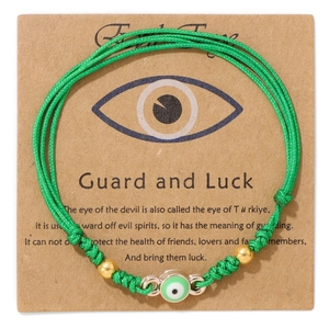 Detail von grünem gewebtem Evil Eye Armband mit Goldperlen auf Kraft-Displaykarte