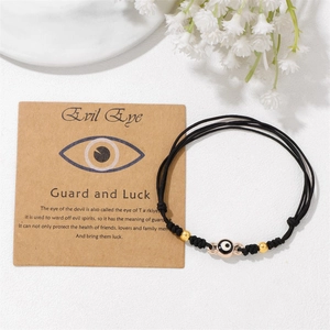 Detaillierte Makroansicht des geflochtenen Evil Eye Armbands mit Goldperlen und Karte