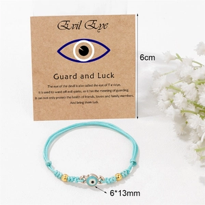 Handgefertigtes Evil Eye Armband mit blauer Kordel und 18k Goldperlen auf Karte