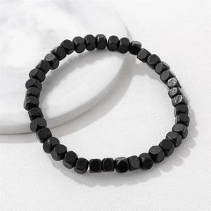 Bracciale minimalista con perline di legno nere su vassoio di marmo con finitura opaca