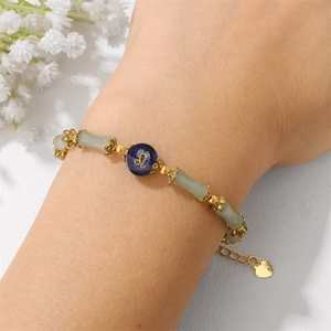 Detail of bamboo jade beads bracelet with Leo zodiac sign and gold petal spacers