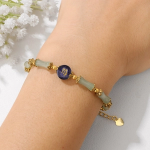 Bamboo-style jade bracelet with Virgo zodiac charm and gold heart pendant on wrist