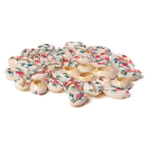 Macro shot of shell-shaped ceramic beads with floral patterns for DIY jewelry making