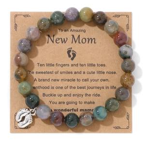 Close-up of beaded rhodonite bracelet with silver baby footprint charm on a gift card