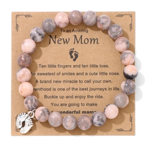 Pink Rhodonite and Zebra Stone beaded bracelet with silver baby footprint charm on gift card