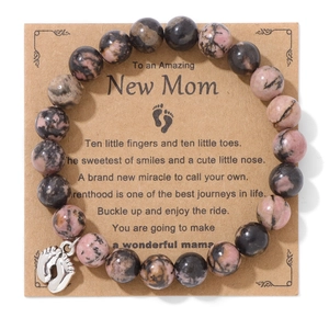 Pink Rhodonite beaded bracelet with silver baby footprint charm on gift card