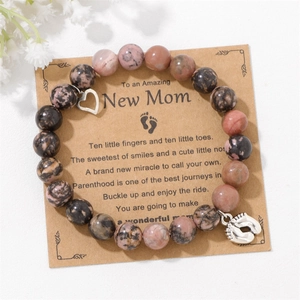 Detail of beaded gemstone bracelet for new moms with heart and baby feet charms