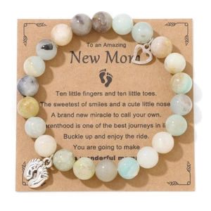 Close-up of blue-purple emperor stone beads with heart and baby feet pendants on card