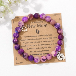 Purple emperor stone bracelet with heart and baby feet charms on a poetry gift card