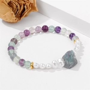Detail van amethist fluoriet kralenarmband met ruwe edelsteen en barokke parels