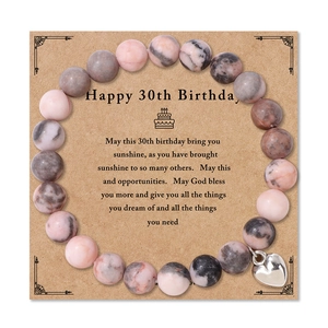 Bracciale di perle in pietra zebra naturale con cuore su carta regalo di compleanno