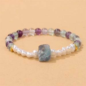 Macro detail van natuurlijke amethist en fluoriet kralenarmband met witte barokparel