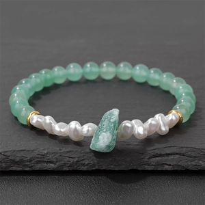 Detail van 6mm groene natuursteen kralen, barokparel en ruw kristal op elastische armband