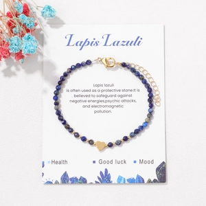 Detailed shot of 3mm Lapis Lazuli beaded bracelet with gold heart charm on display card